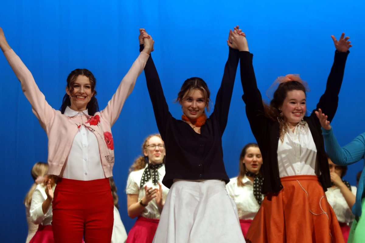 Holding hands, seniors Sophia Estes and Madeline Olivier and sophomore Grace Holland prepare to bow during the curtain call.