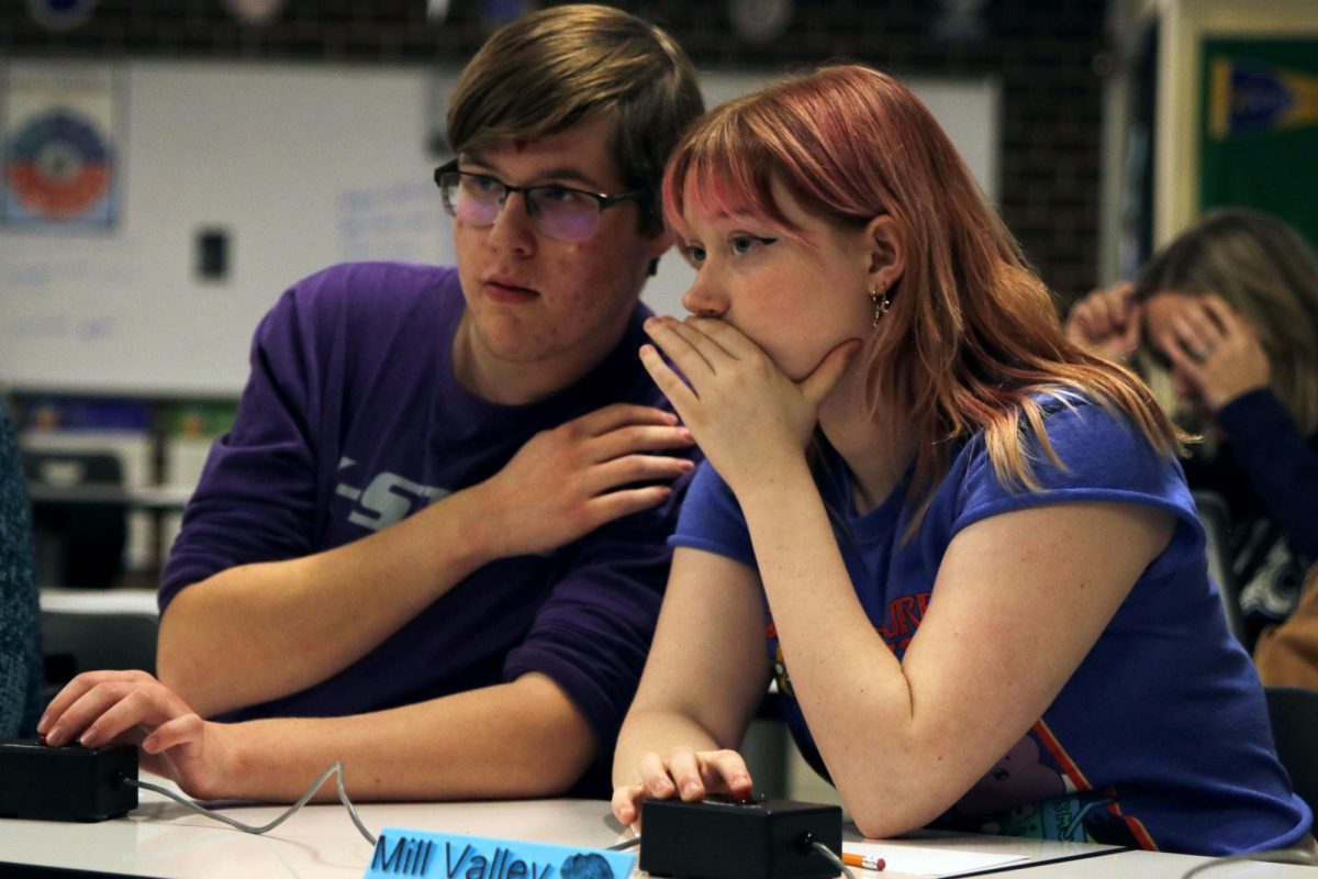 Whispering, senior Emma Clement and sophomore Ian Weatherman discuss their answer to a fine arts question.