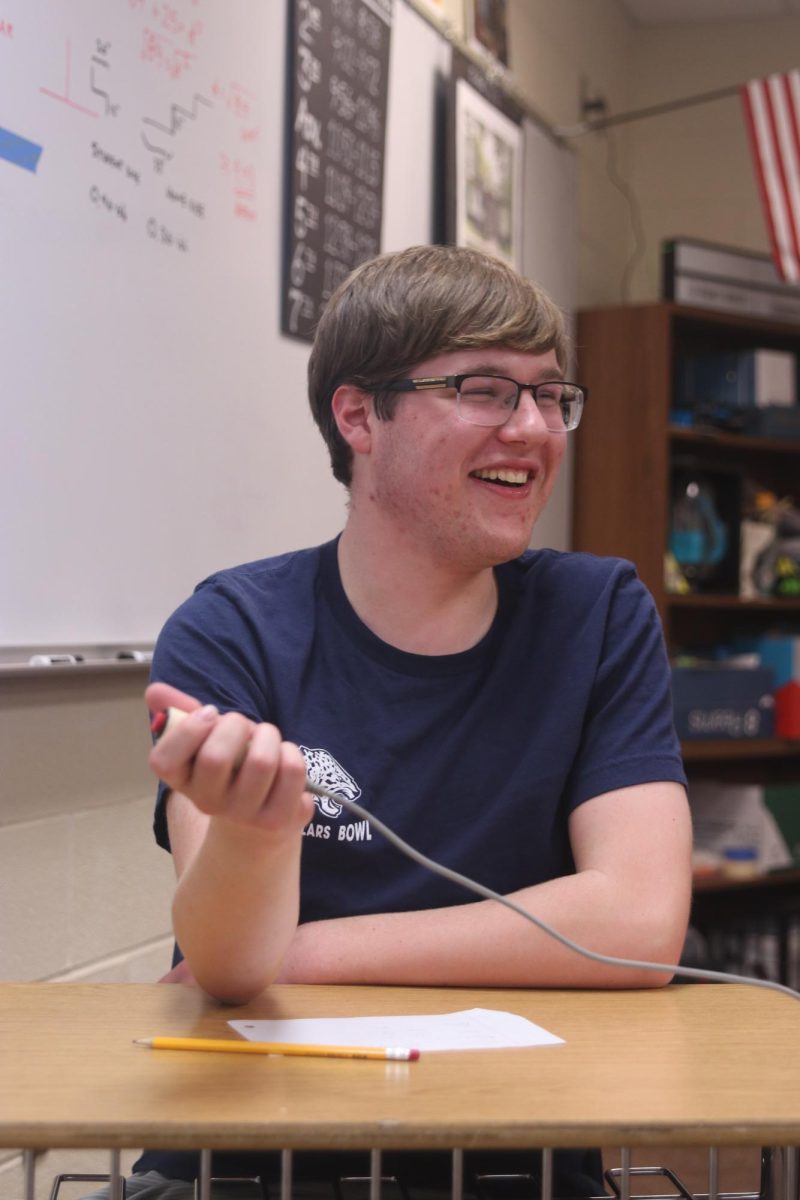 Laughing, sophomore Ian Weatherman listens as the moderator reads out the correct answer.