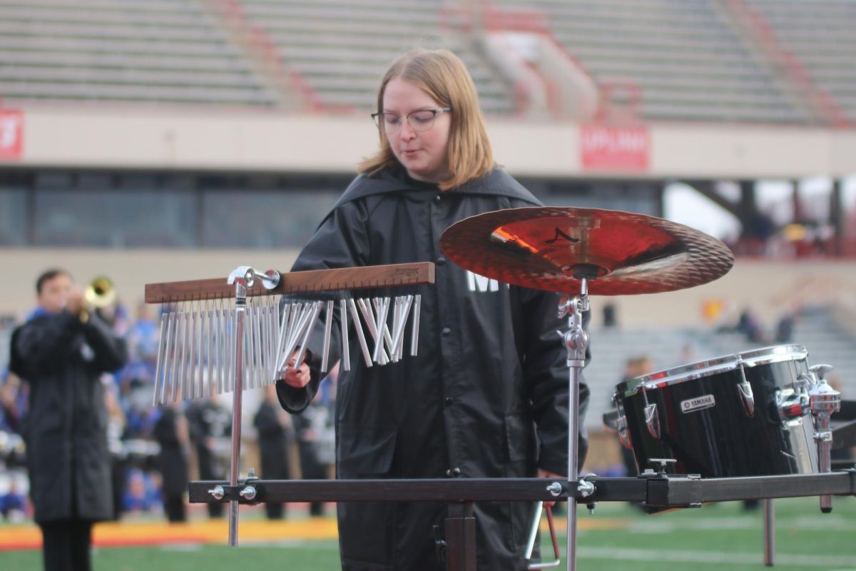 Junior Lilly Rugenstein leads the percussion section during the bands halftime performance.