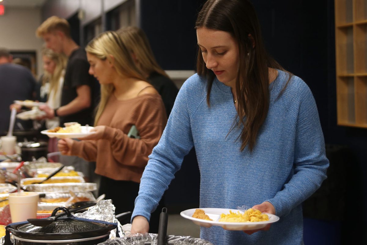 Ready for a feast, senior Christina Atkinson scoops food onto her dinner plate.