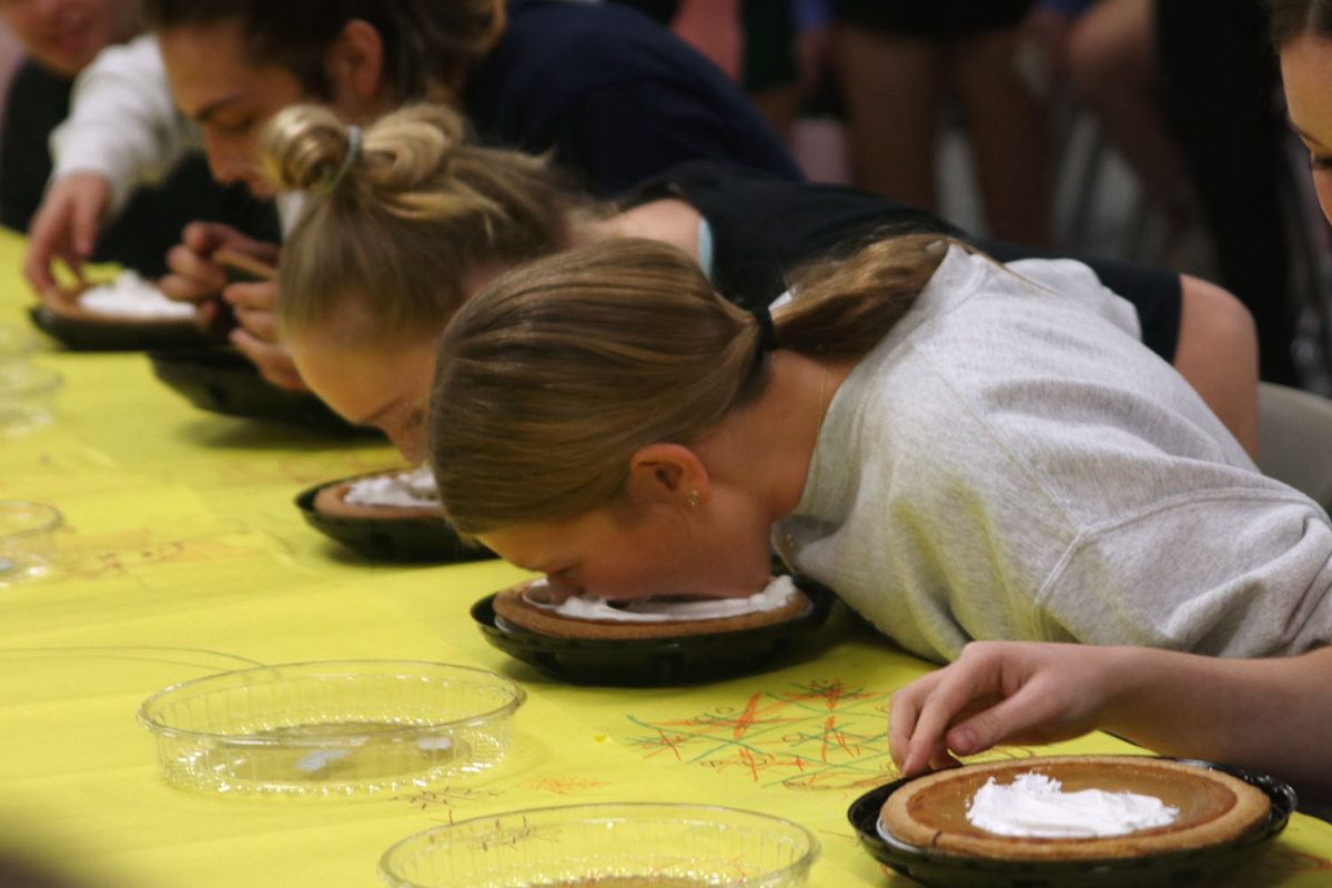 Participating in the pie eating contest, freshman Maebelle Suderman goes face first into the pie.