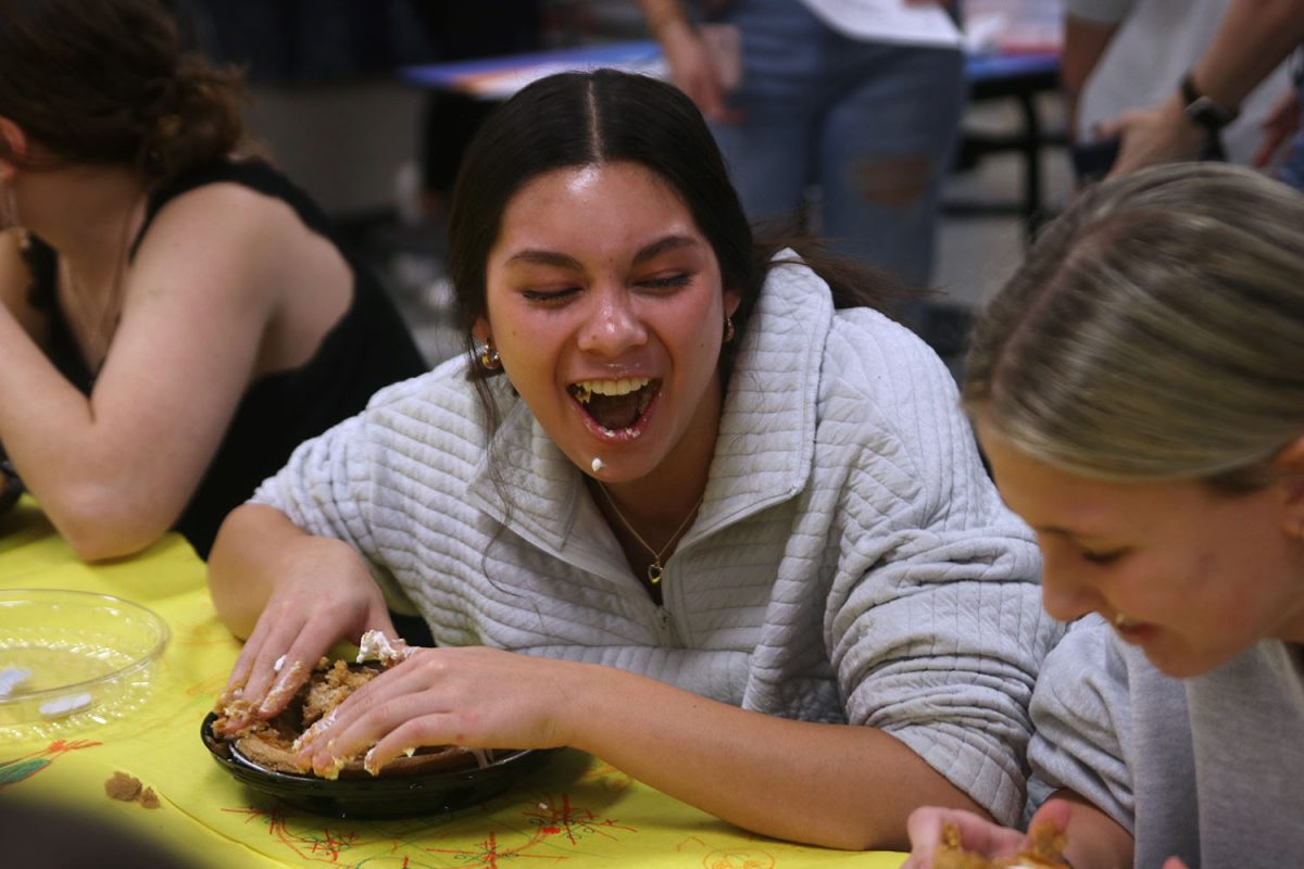 Having a blast, sophomore Stella Beins competes in a pie eating contest at clubsgiving.
