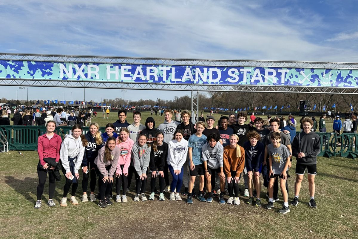 Standing in front of the starting line, the cross country team posses for a picture.