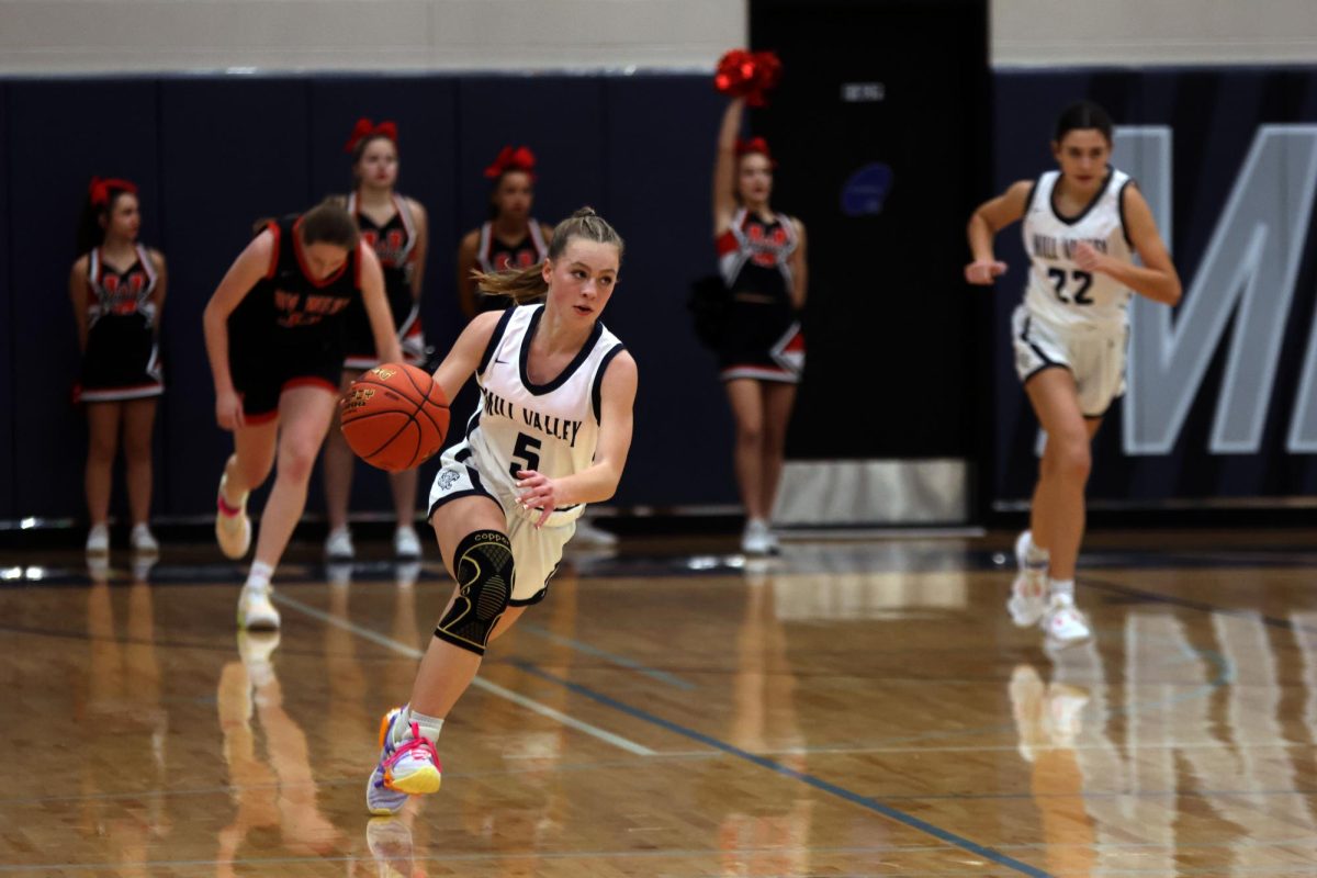 Junior Josie Benson dribbles down the court.