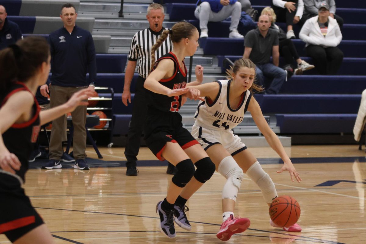 Junior Averie Landon uses a stiff arm to block her opponent from getting the ball. 