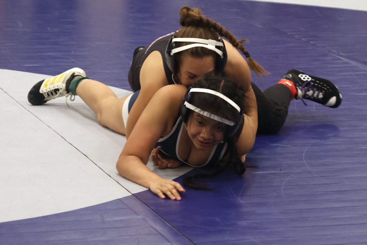 Junior Jackie Gutierrez thinking of a way to get out of the grip of her opponent.
