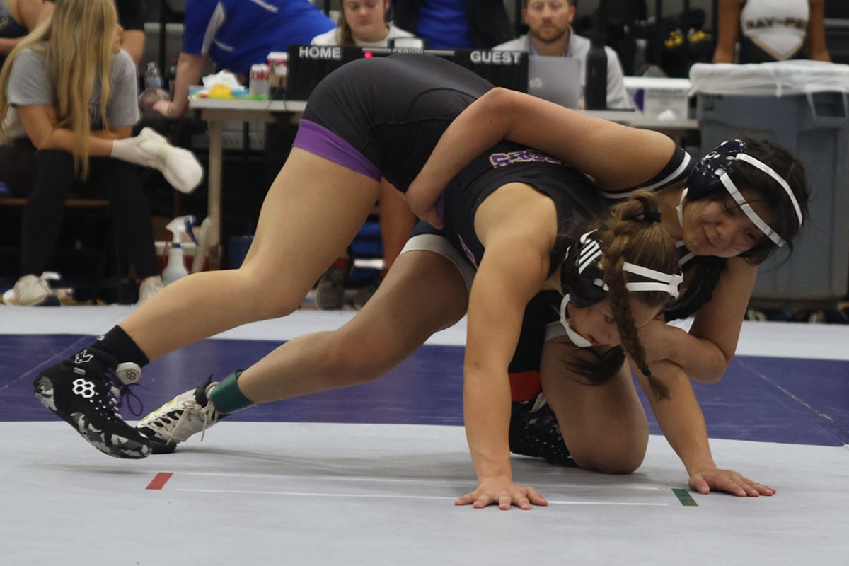 Making sure she can not move, junior Jackie Gutierrez holds down her opponent.