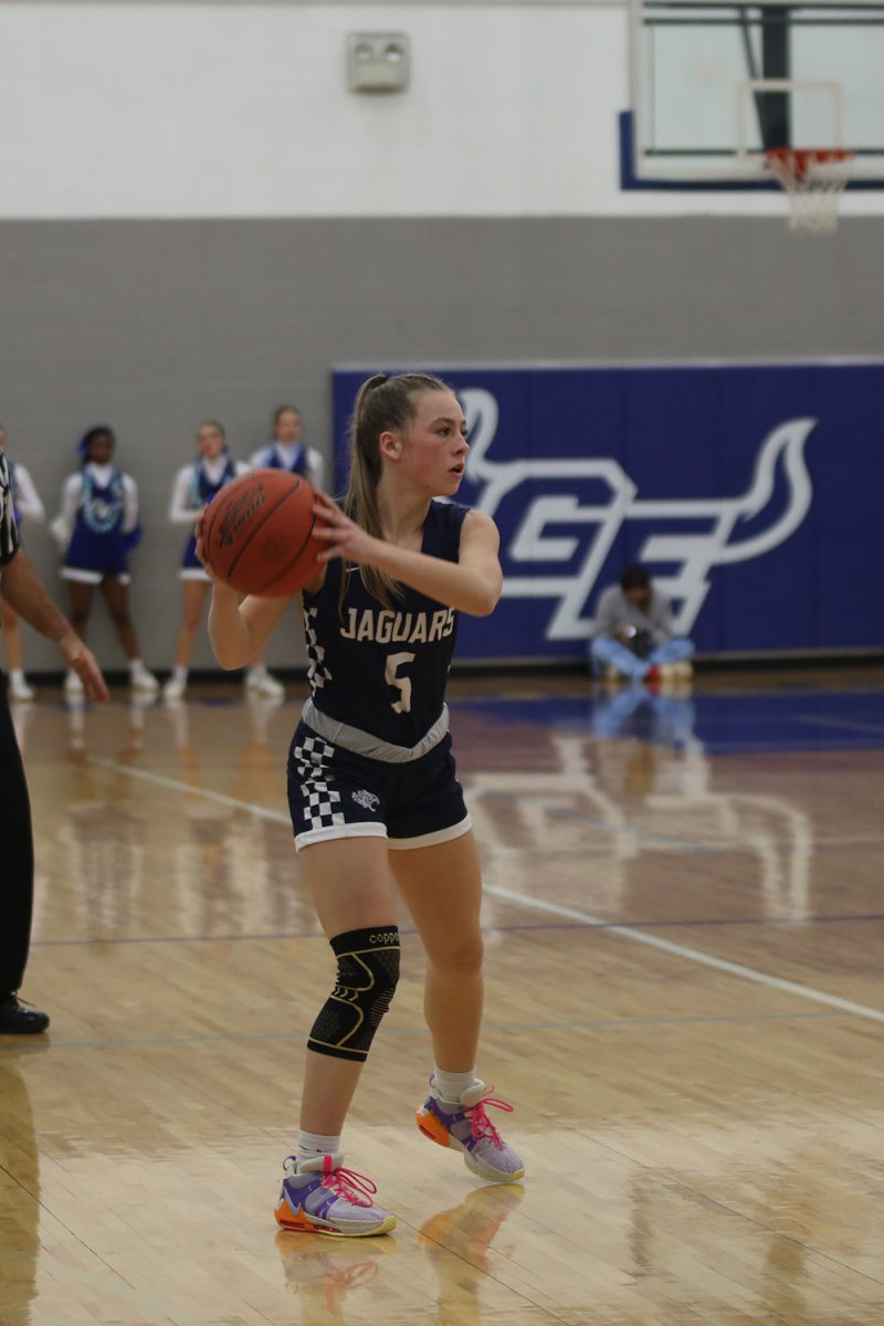 Scanning the court, junior Josie Benson prepares to make a pass to a teammate.