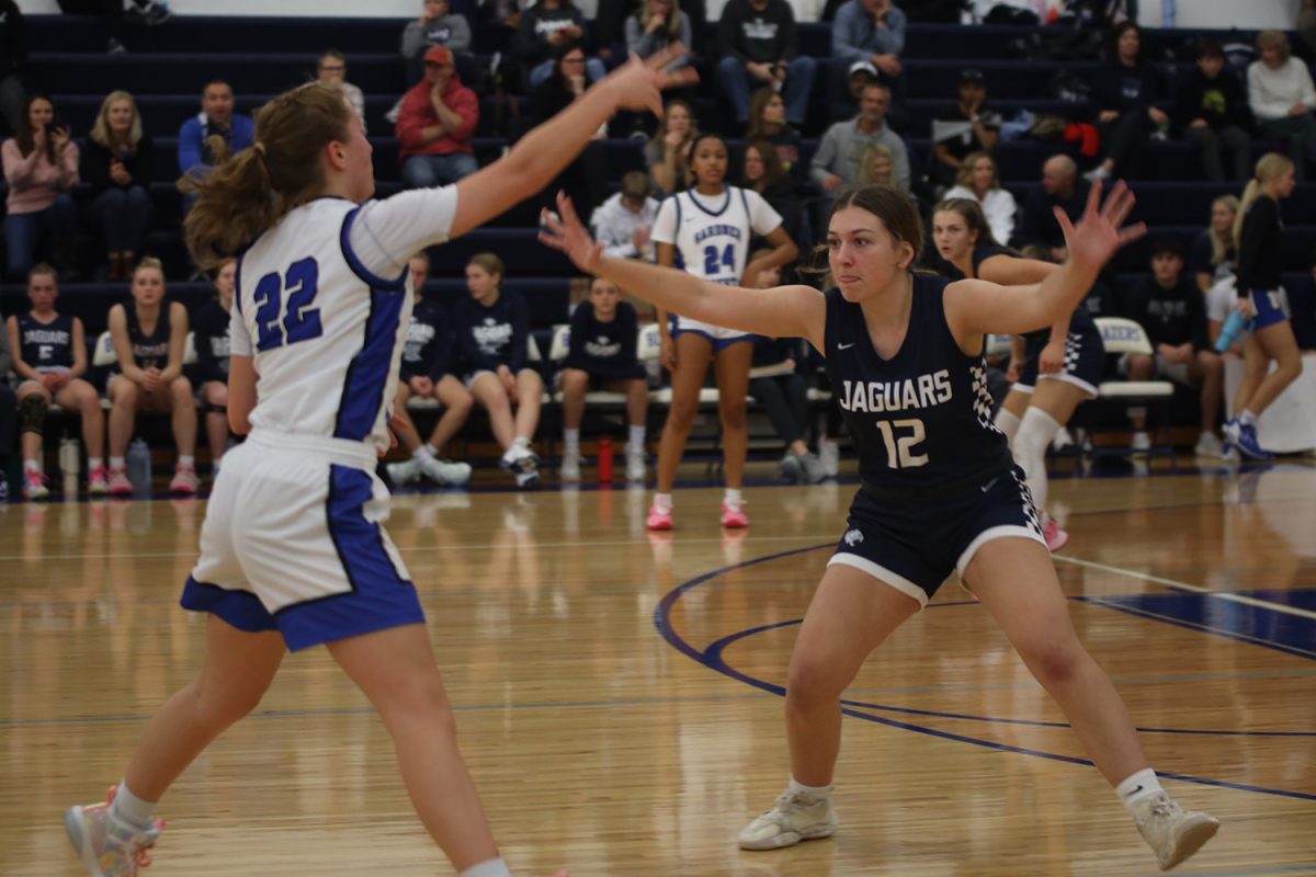 With her eyes on the ball, junior Gracie Kurzejeski tries to block her opponent from scoring.