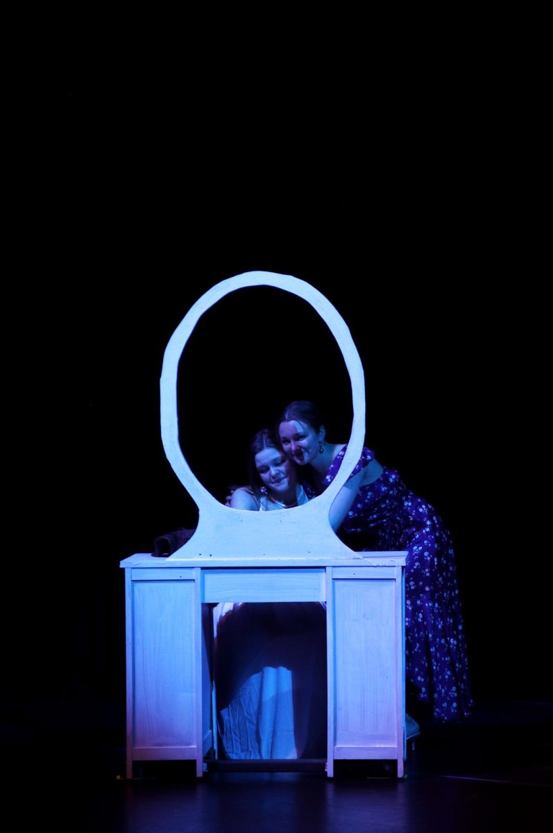 Looking through the mirror, Sophia and Donna, played by seniors Caroline Alley and Grace Cormany, hug while singing “Slipping Through My Fingers.”