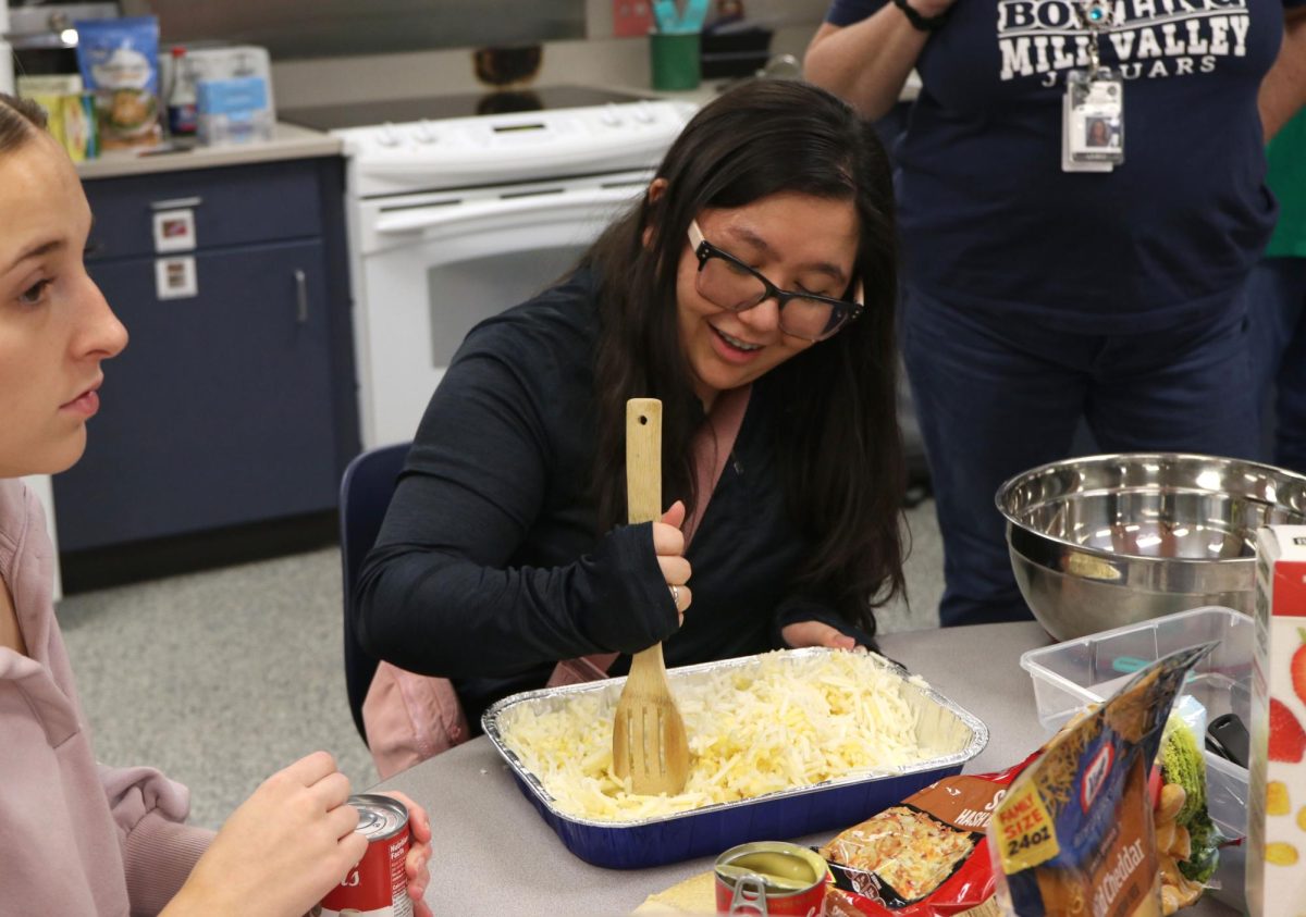 Preparing for the party, senior Mya Diacono mixes the food together in the pan.