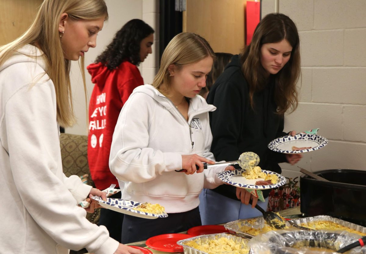 During the party, seniors Natalie Moreland, Jaiden Fisher and Banner Hall scoop food onto their plates.
