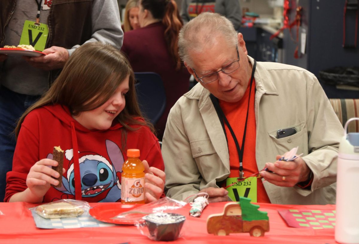 During the Christmas party, freshman Emma Cummings gets a present from her grandpa.