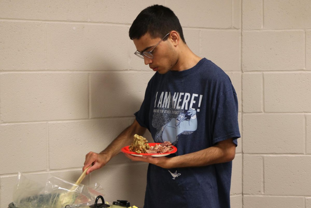 Putting food on his plate, junior Bojidar Green gets ready for the Christmas party. 