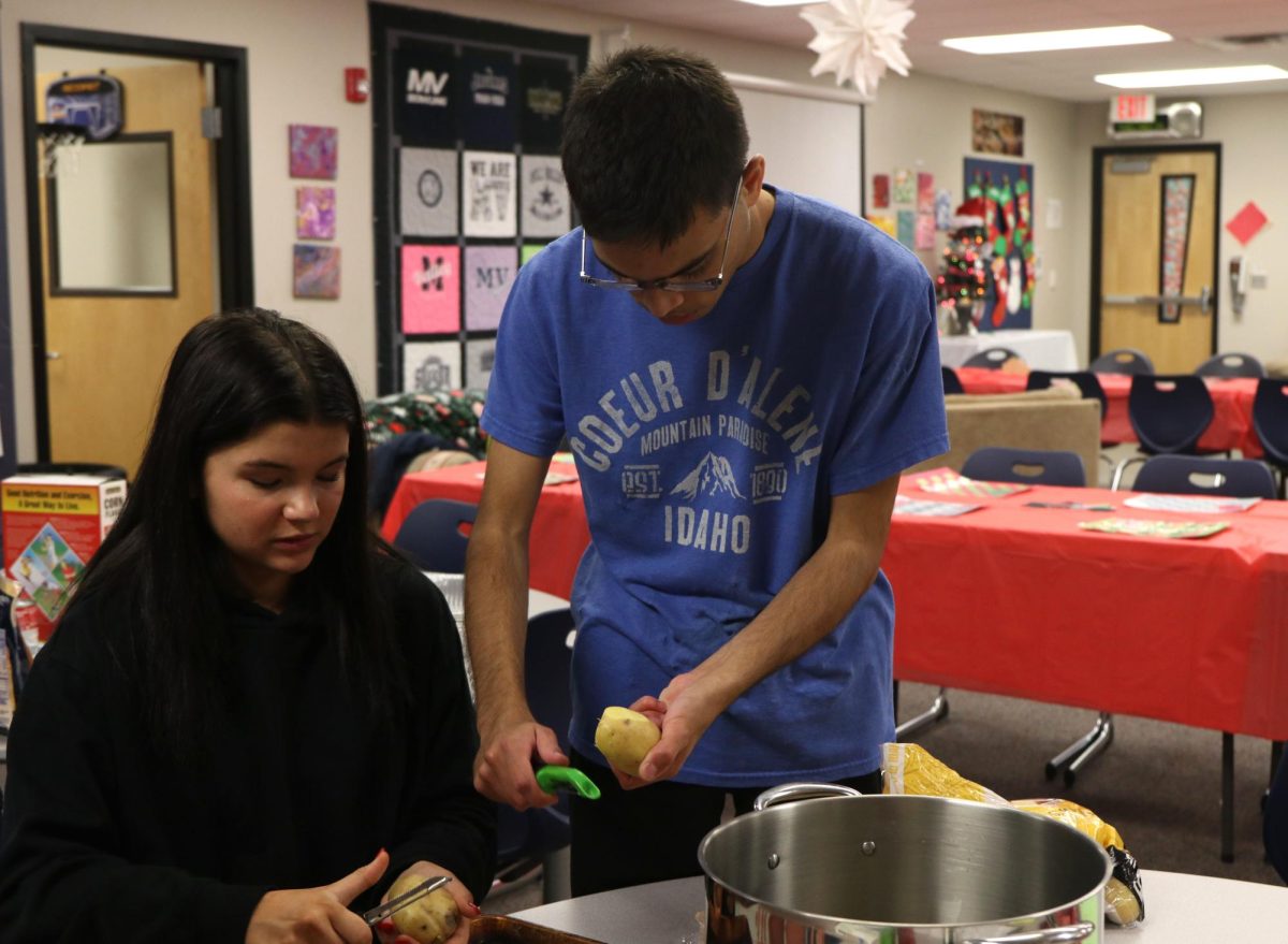 Preparing for the Christmas party, junior Bojidar Green cuts a potato.