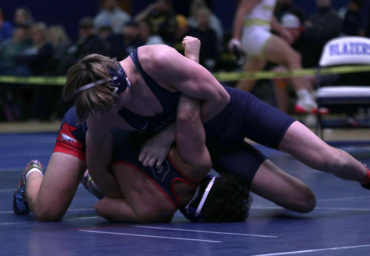 Locking his arms, senior Colin McAlister holds his opponent to the ground.
