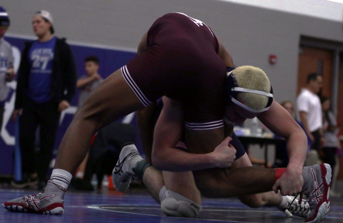 Holding his opponents legs, senior Maddox Casella locks his opponents into place.