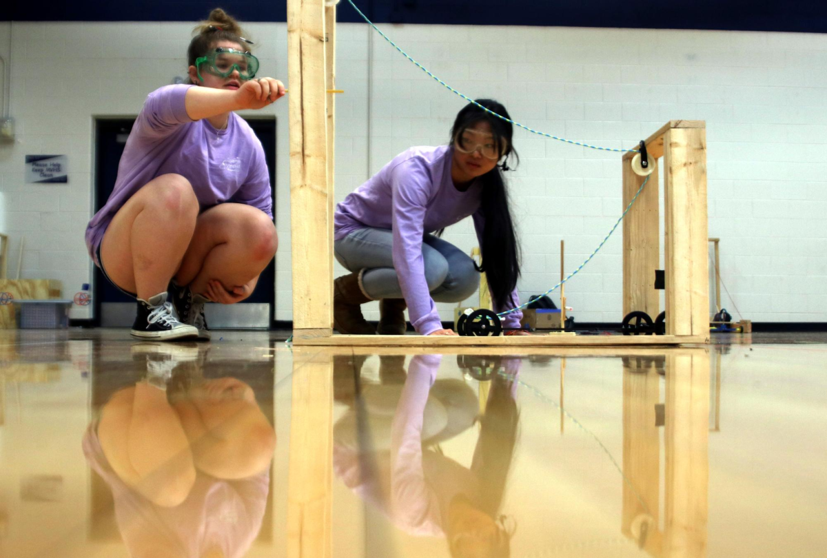 Juniors Hannah Lewis and Alivia Thatlor prepare their machine for the Scrambler event.