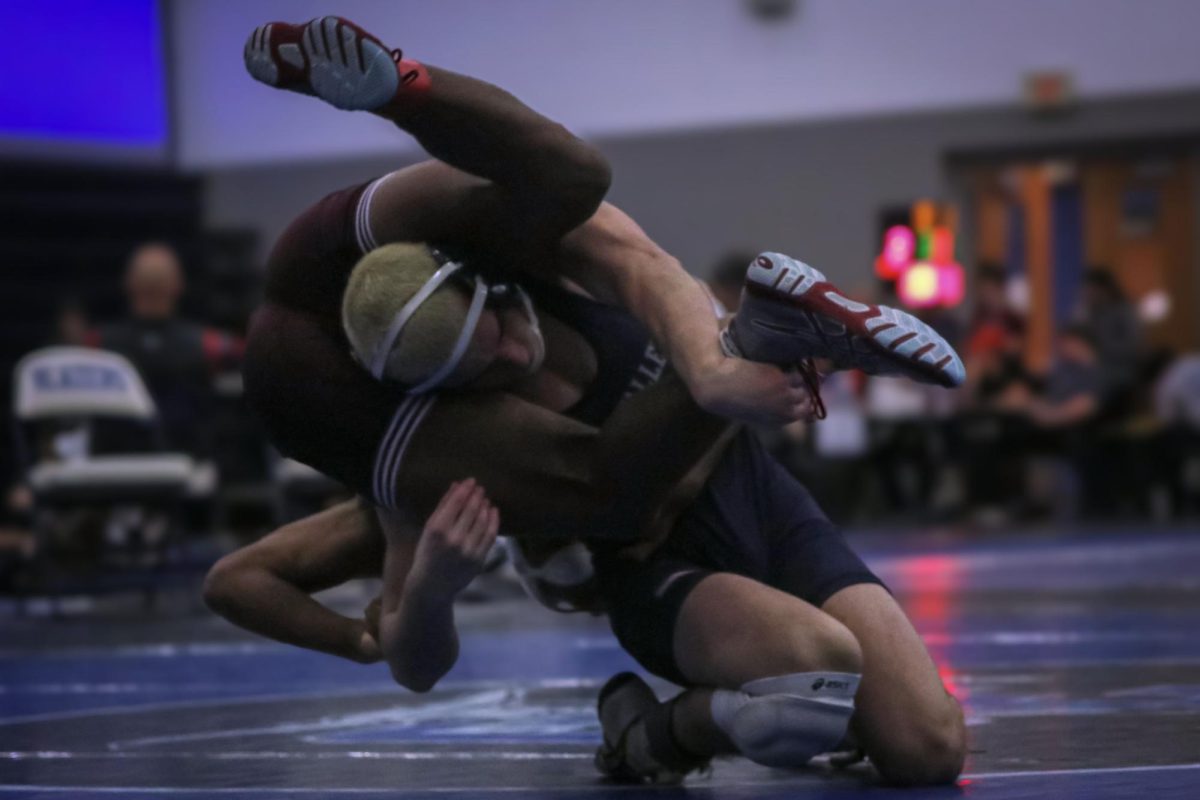 With his opponent wrapped around him, senior Maddox Casella throws the opponent to the mat.