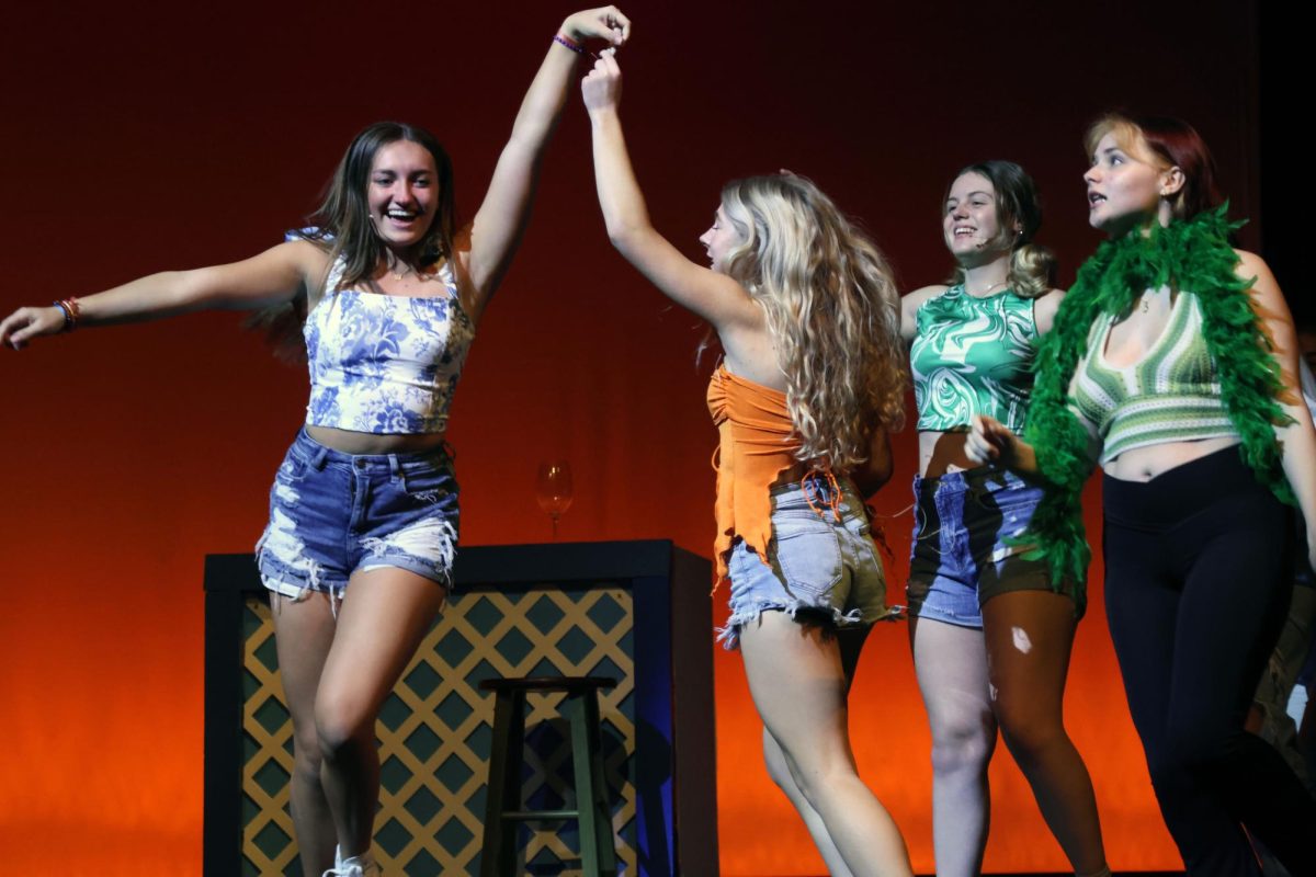 Happily dancing around the stage to the song Lay all your Love on me”, Sophie, played by junior Allyson Makalous, holds hands with Ali, played by senior Violet Hentges. 