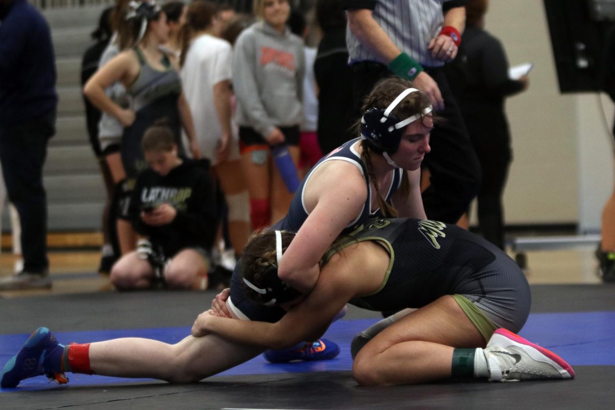 Looking down, junior Piper Wendler pins her opponent on the ground. 