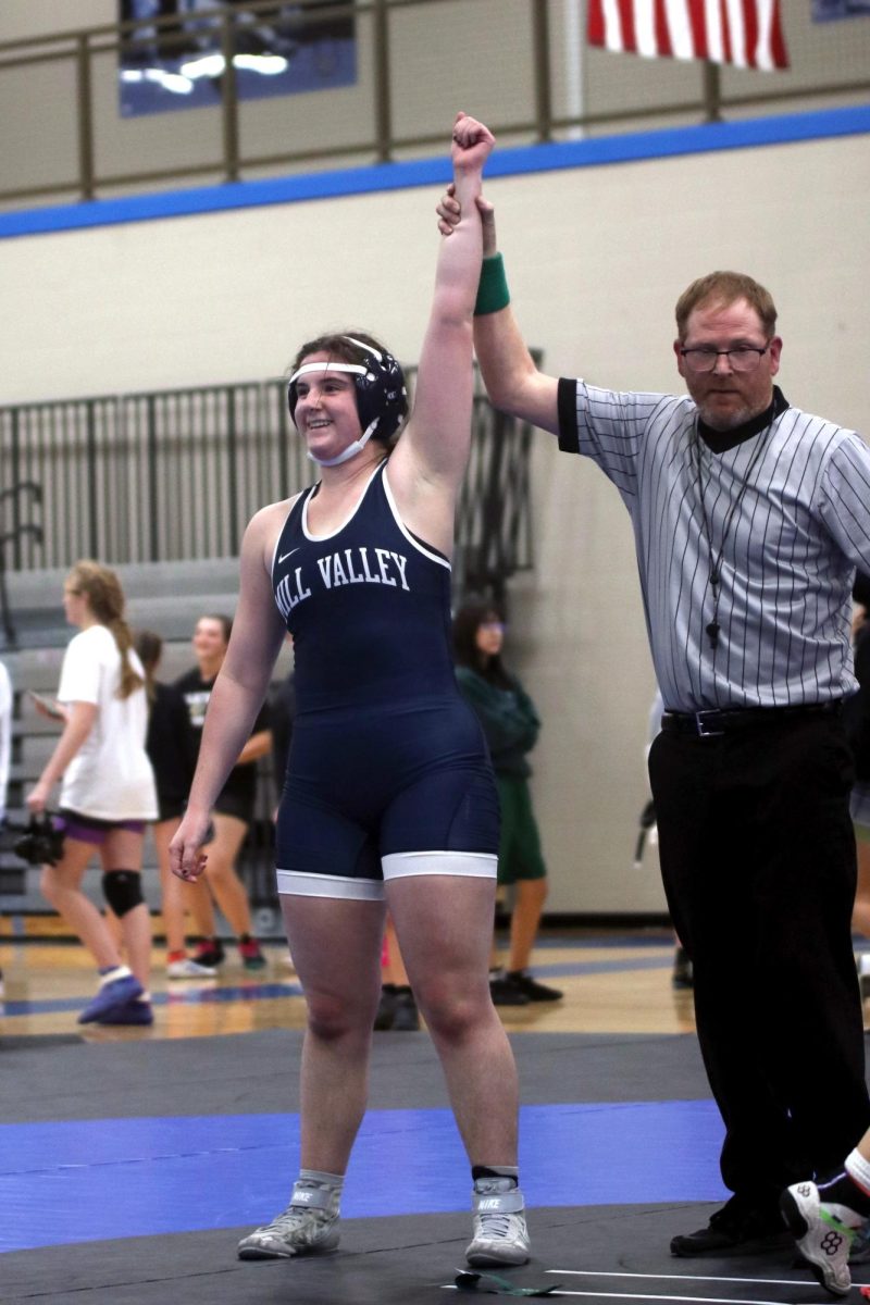 Arm held up by the referee, junior Lexus Pennel smiles after a winning match.