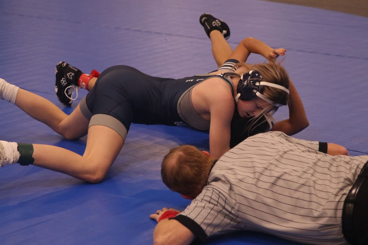 Freshman Chris Hale pins her opponent to win her wrestling match.