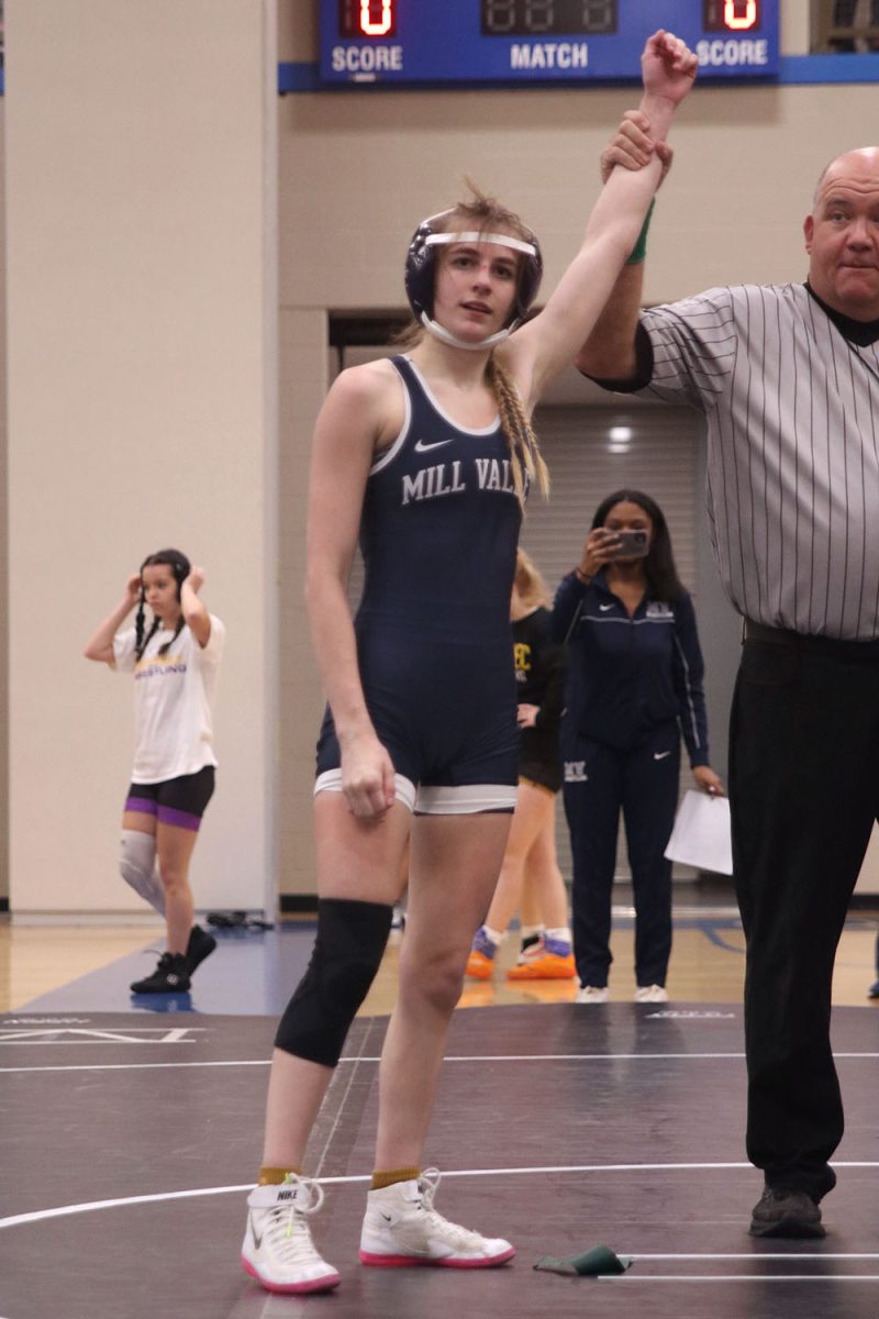 With a win in her wrestling match, sophomore Finley Rose gets her hand raised by the referee.