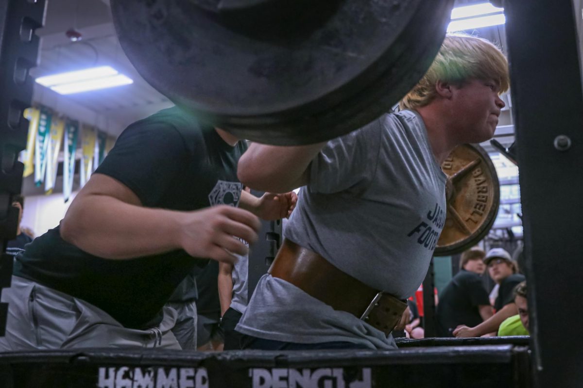 Wearing his weight lifting belt, junior Eric penner squats 465 pounds.