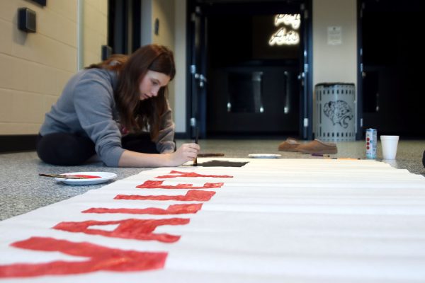 Junior Emmy Chezem paints a sign for Valley Productions, the theme of this years Winter Homecoming.