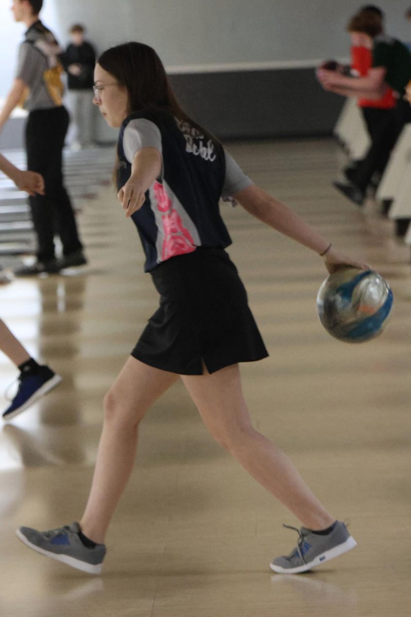 Approaching the lane, freshman Ella Deihl rolls her ball down. 