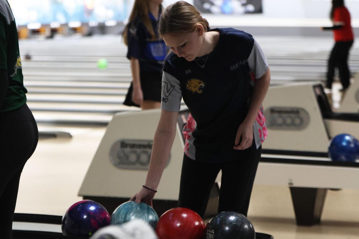 Reaching for her bowling ball, freshman Rylee Slavin gets ready for her next turn. 