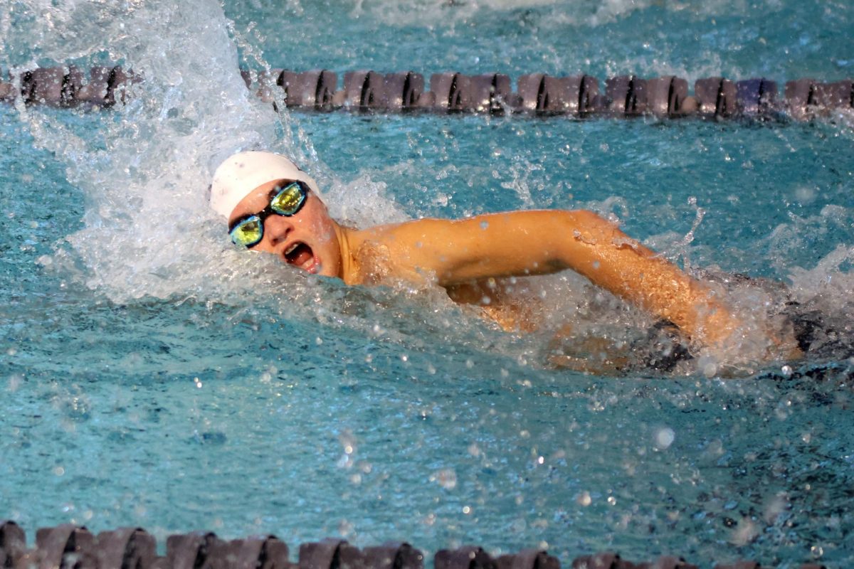 Taking a breath, sophomore Pete Williams swims the 50 yard freestyle.