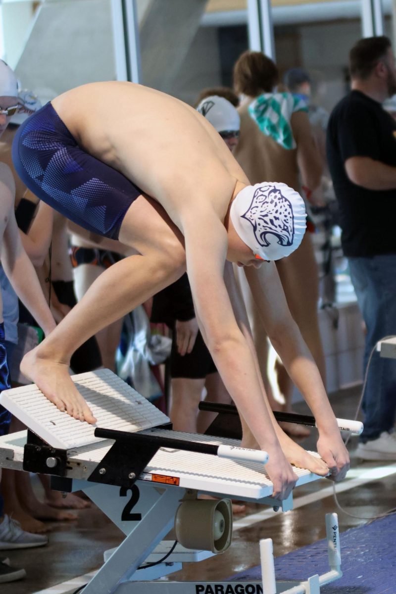 Eyes on the water, freshman Andrew Martin prepares to swim the 100 yard butterfly.