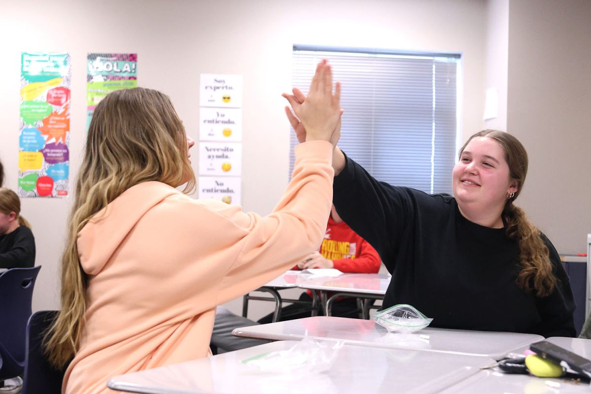 Seniors Kate Haney and Leah Dresvyannikov share a high five as their own celebration of the new year in the Spanish National Honor Society.