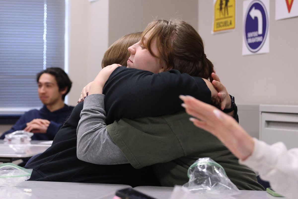 Senior Gwen Heideman embraces a friend as is traditional for ringing in the new year in spanish cultures at the Spanish National Honor Society meeting.