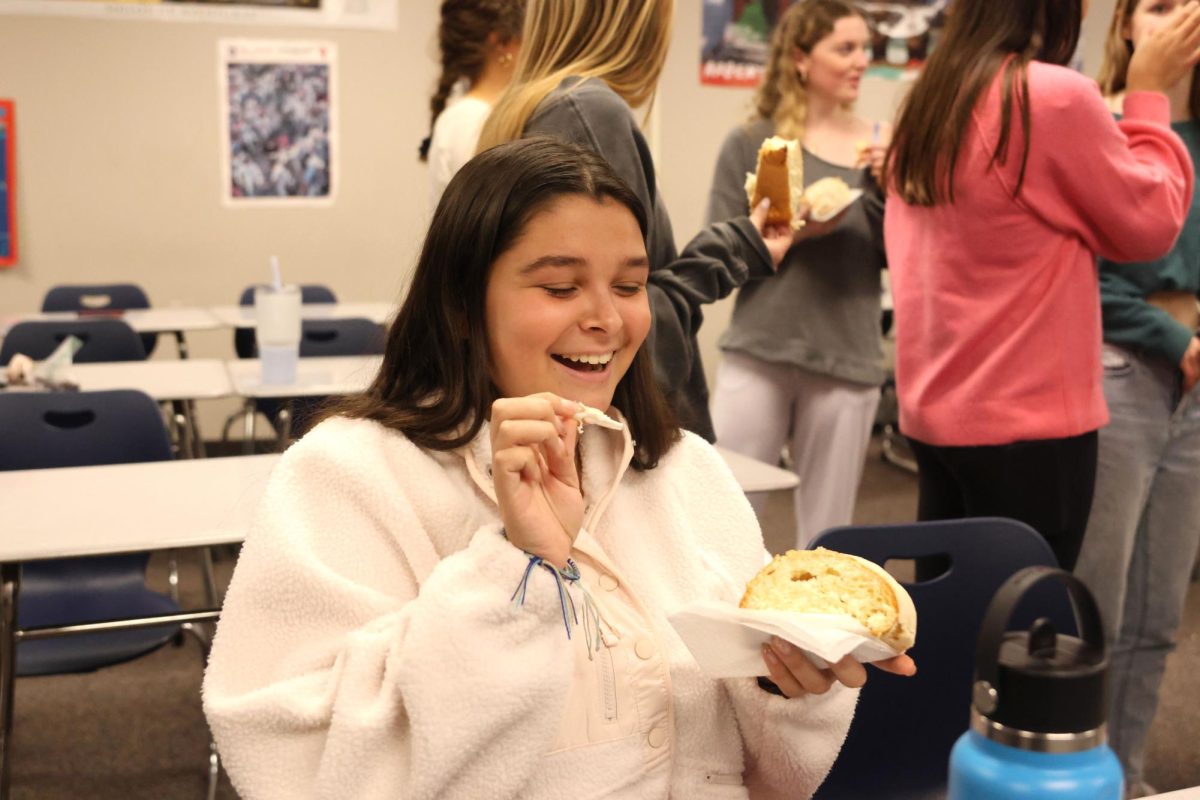 Grinning as she extracts the small plastic doll, junior Celeste White enjoys a slice of Rosca de Reyes.