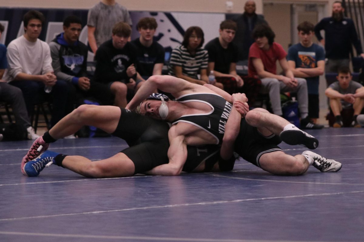 With his arms around his opponent, senior Maddox Casella tries to escape his opponents grasp.