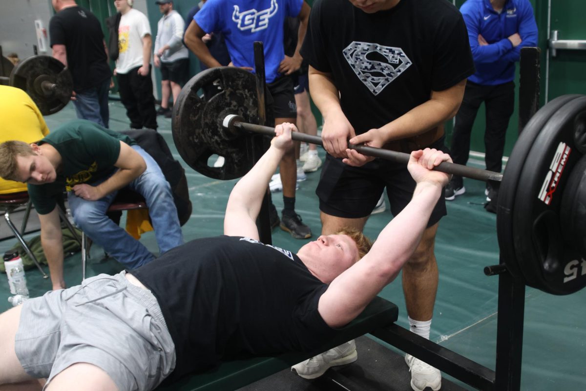 Focusing on the weights, junior Conner Woods gets ready to bench press.