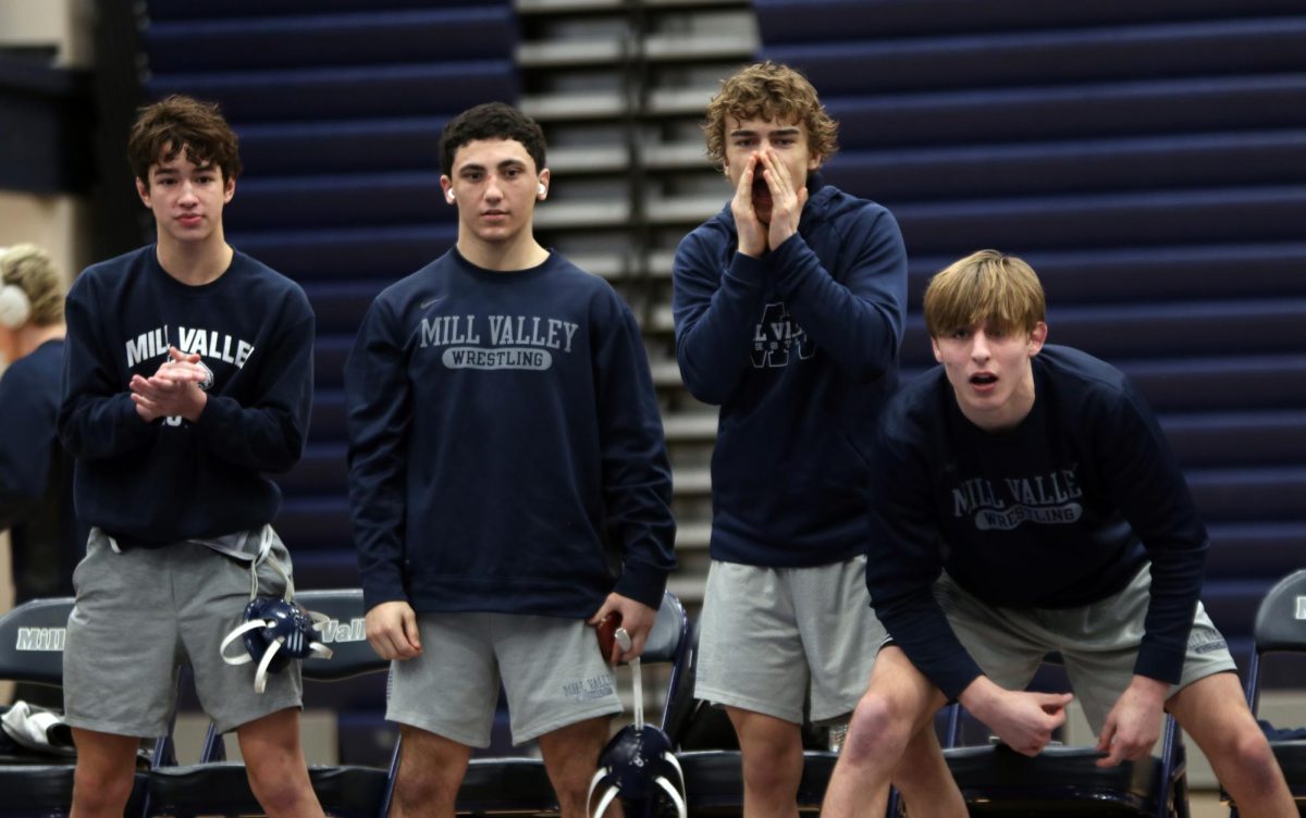 Cheering for their teammate, junior Noah Pham, freshman Ryder Farley, and seniors Brady Mason and Colin McAlister watch the match intensely.