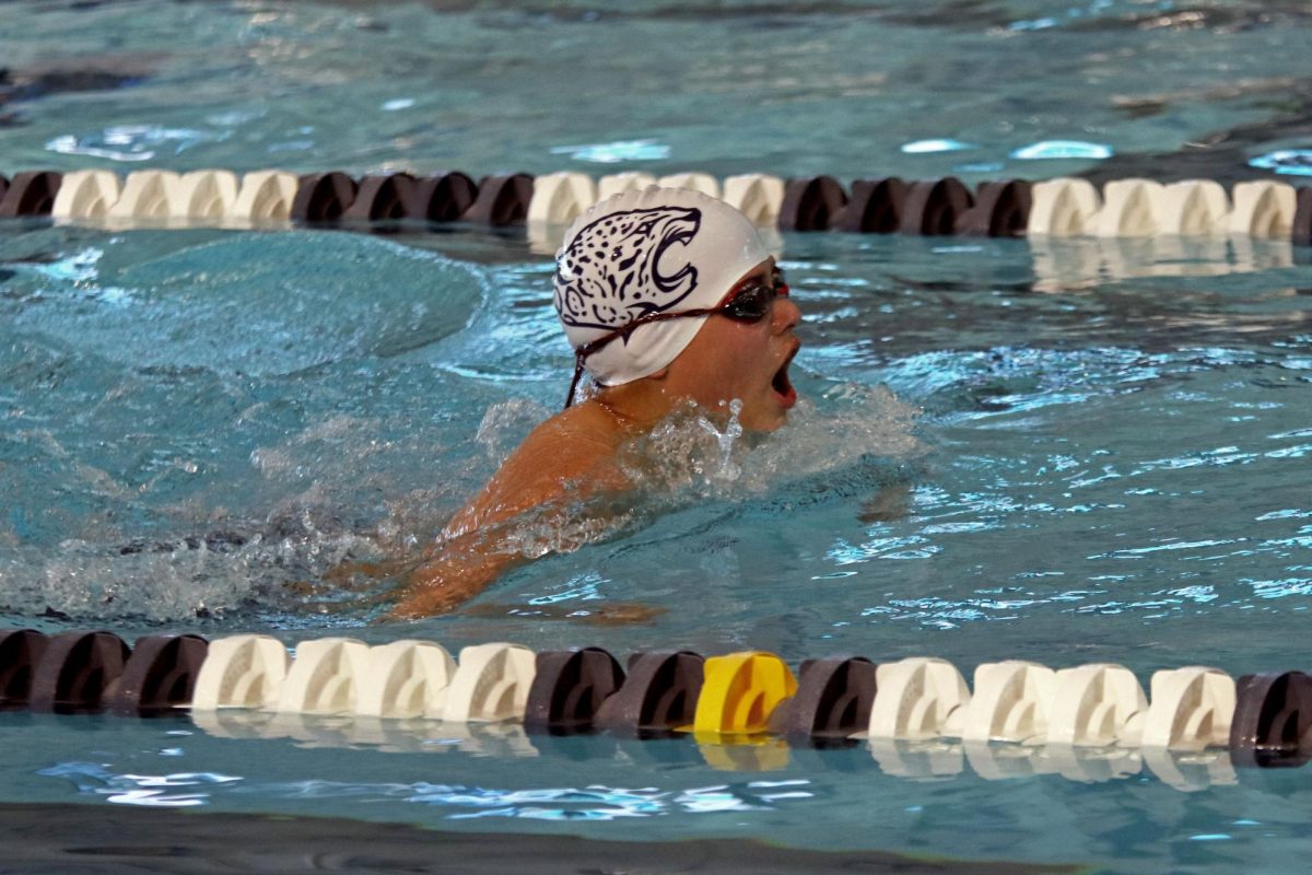 Coming up for air, freshman Turner Bruce breaststrokes down the lane.