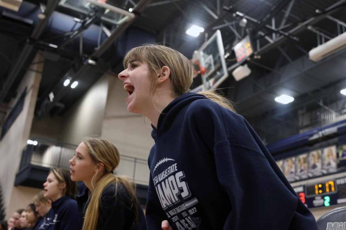 Invested in the match, sophomore Finley Rose cheers on her teammate from the sidelines. 