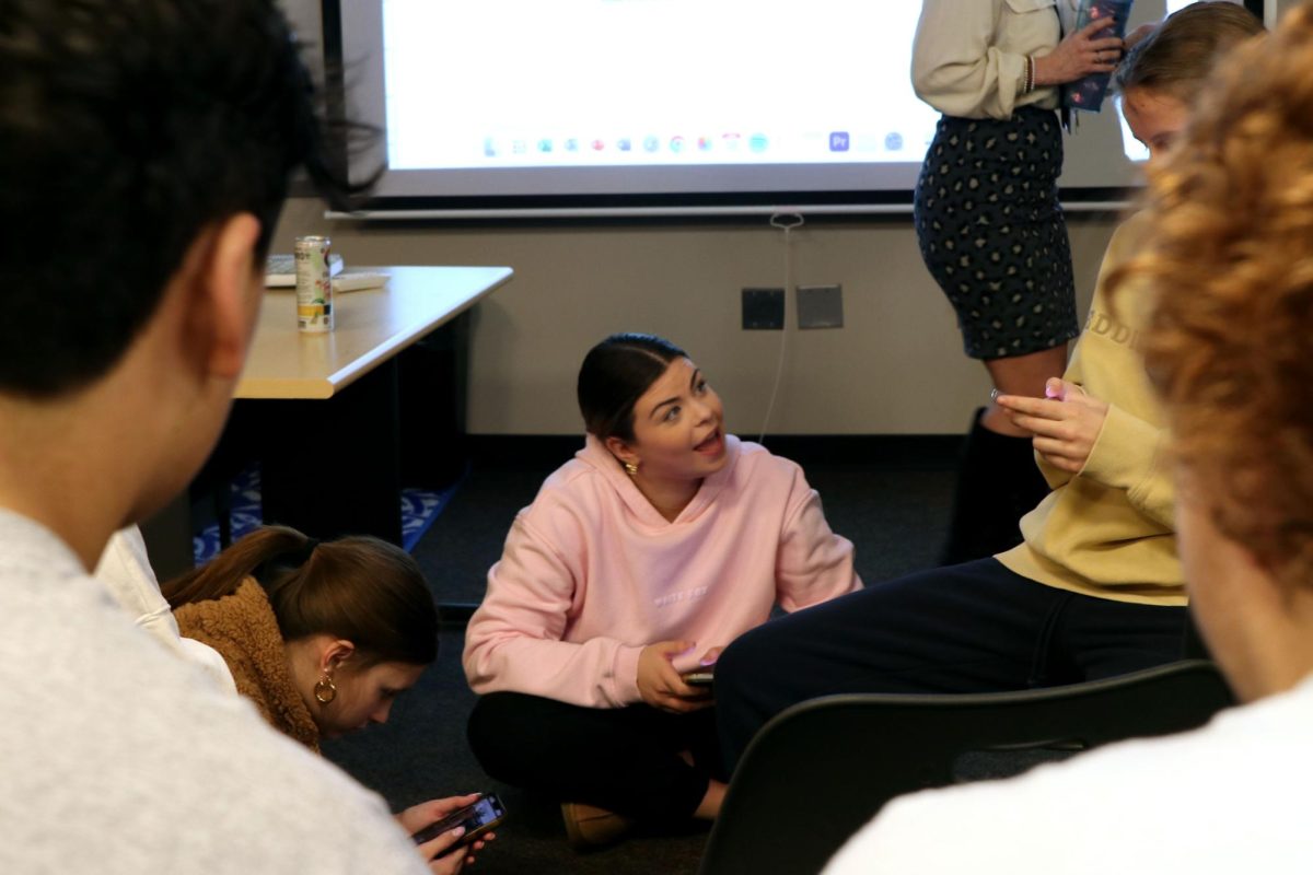 Enthusiastically discussing ideas, Student Body Treasurer Kate Pfeister discusses with a group of StuCo representatives in their early morning meeting.