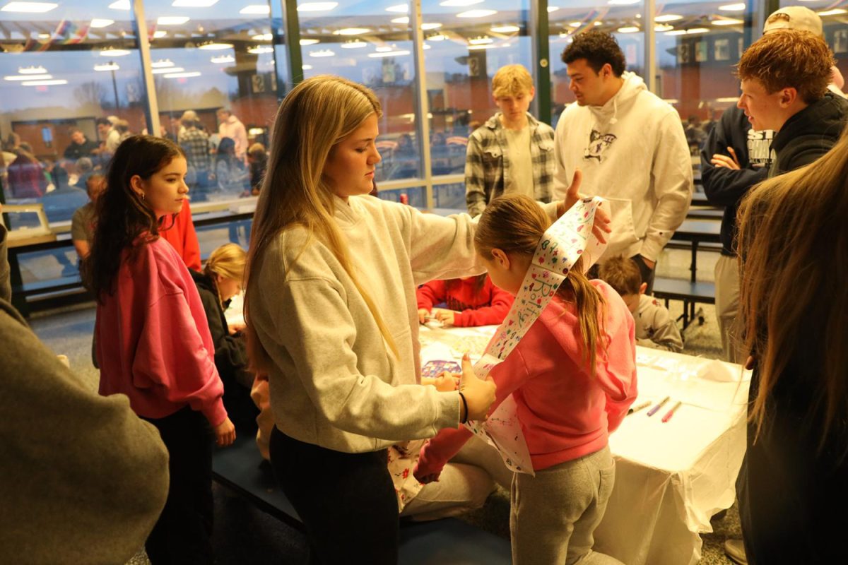 Senior Brooke Bellehumeur puts a decorated sash on a JCPRD student Wednesday Jan. 31.