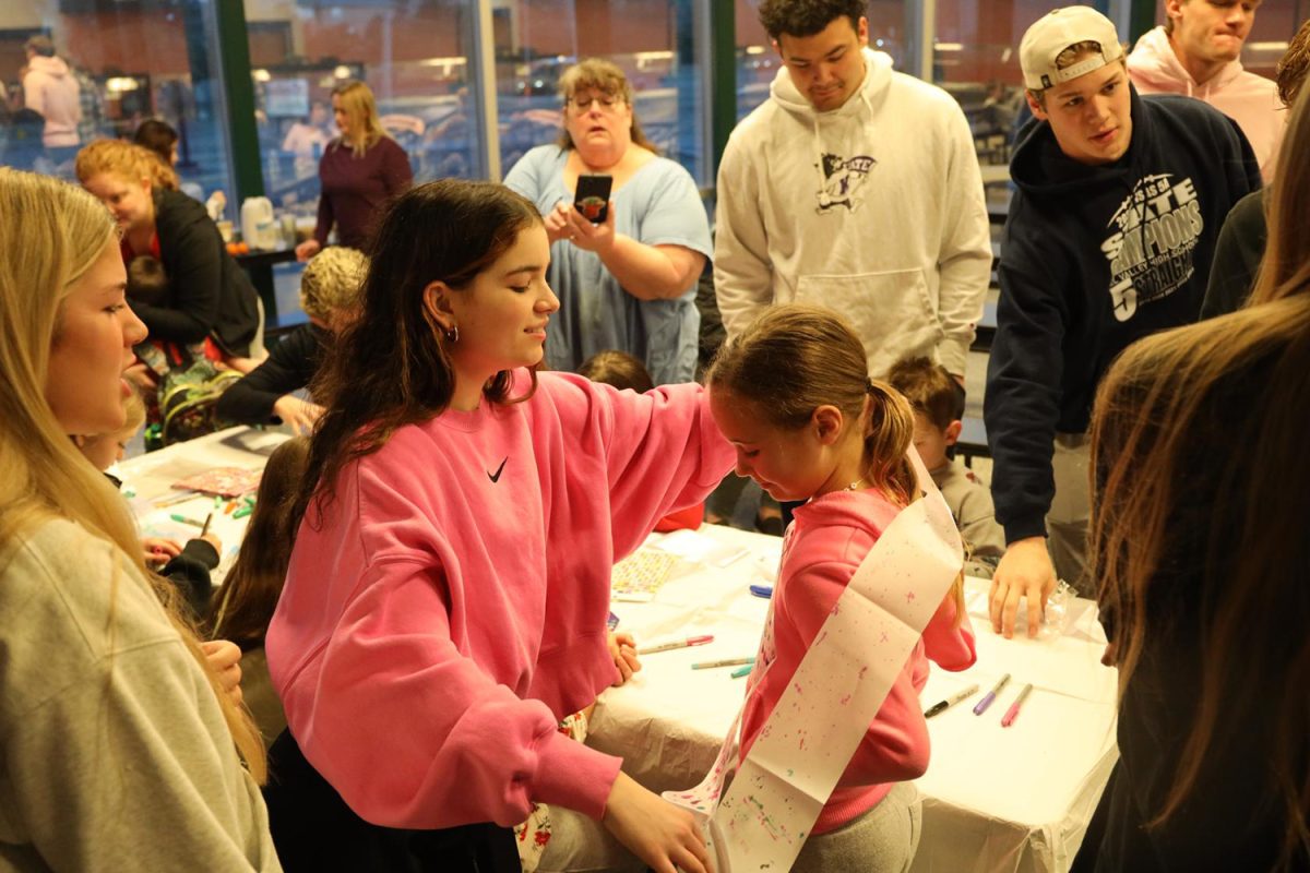 After decorating, senior Keira Bret puts her sash on a JCPRD student Wednesday Jan. 31.