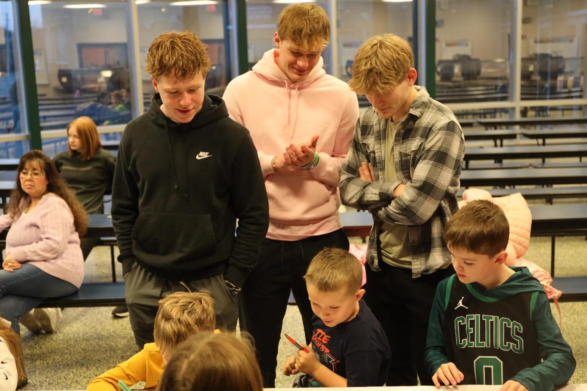 Seniors Garrett Cronin, Connor Clifton, and Bryant Wiltse help JCPRD students decorate their sashes Wednesday Jan. 31.