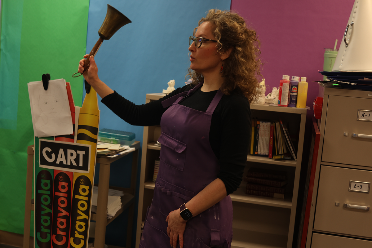 Art teacher Elizabeth Pursell rings a bell to get students attention to let them know that its time to clean up.