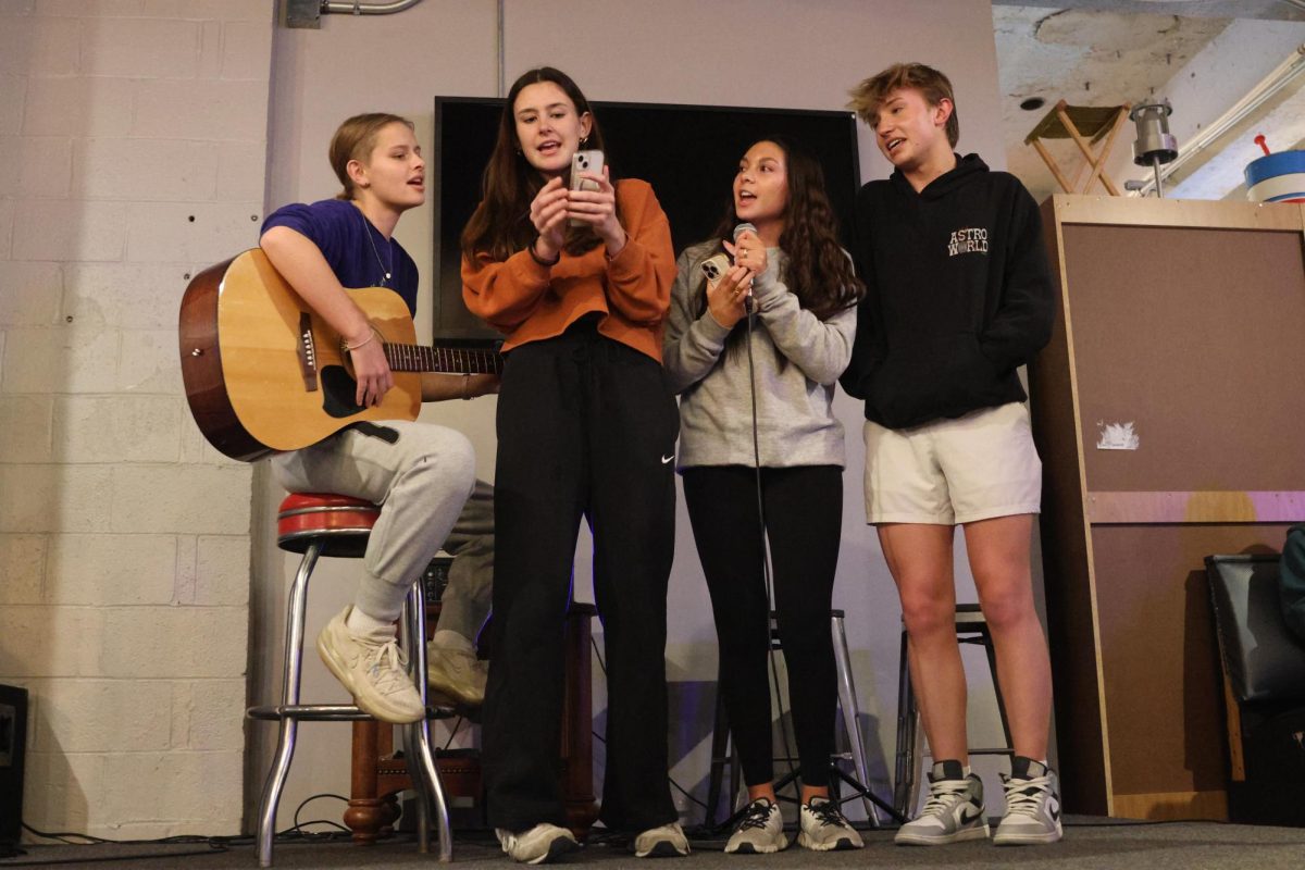 Sophomores Sienna Suderman, Paige Roth, Stella Beins and Gus Goetsch come together on stage to perform a song. 