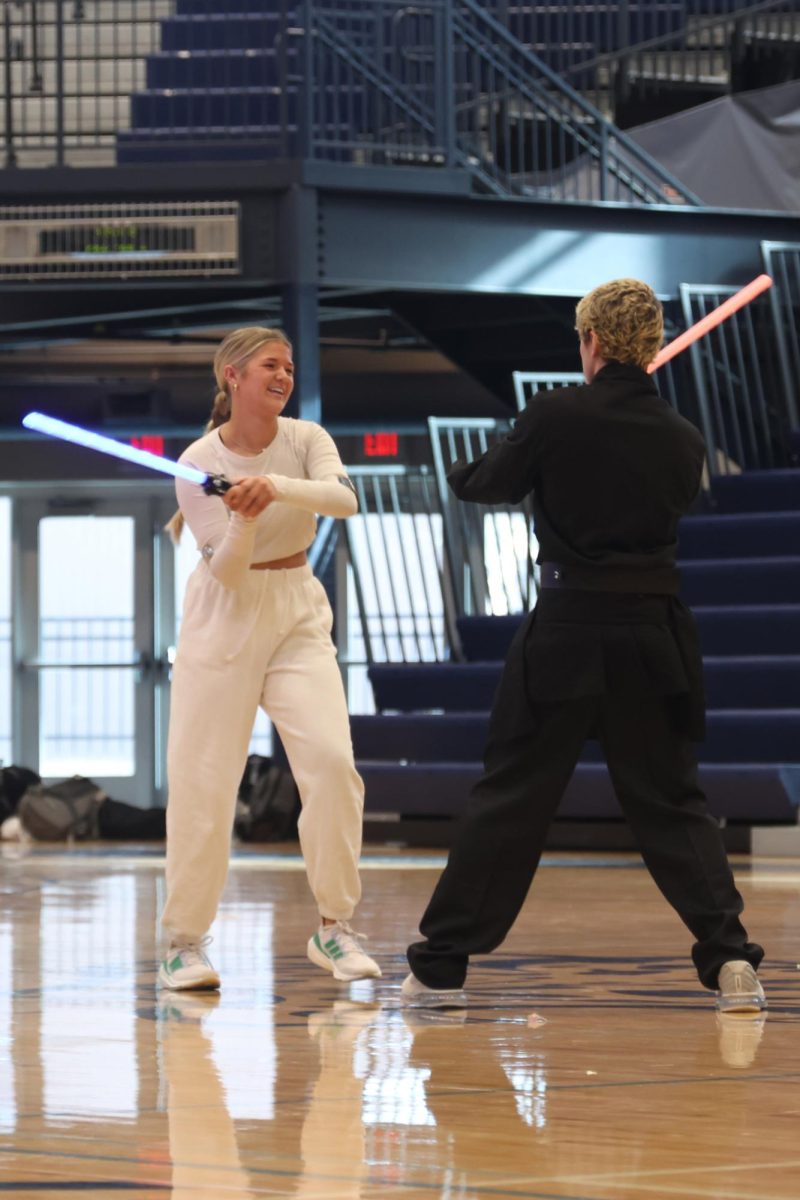 Lightsabers outstretched, winter homecoming candidates seniors Brooke Bellehumeur and Maddox Casella act out a battle scene.